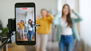 Two girls filming content on mobile phone for TikTok